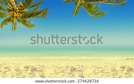 Vintage effect (retro style). Empty wooden table, coconut palm tree, ocean and sandy beach. Tropic island background.