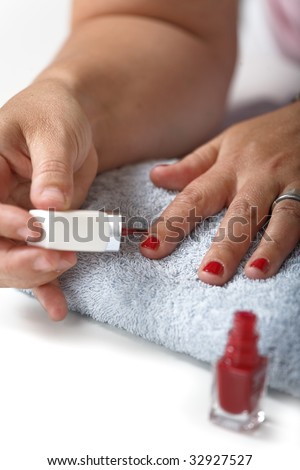 Woman putting on nail polish on finger nails