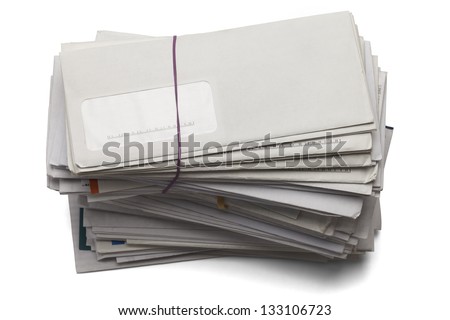 Mail stacked high of unpaid bills isolated on a white background.