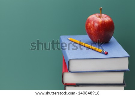 Close up of Classroom Chalk Board, Books and Apple with Copy Space.