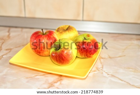 Four apples on a plate