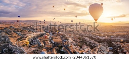 Hot air balloons flying above Göreme, Cappadocia (Kapadokya) Anatolia, Turkey at sunrise. Panoramic view of villages and fairy chimneys. Popular touristic destination for summer vacation holidays ストックフォト © 