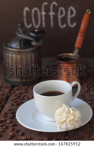 the Turk and a coffee grinder on a table with coffee grains, cake on a plate