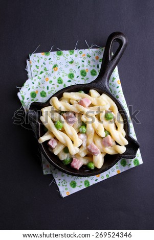 pasta with peas and ham in a pan