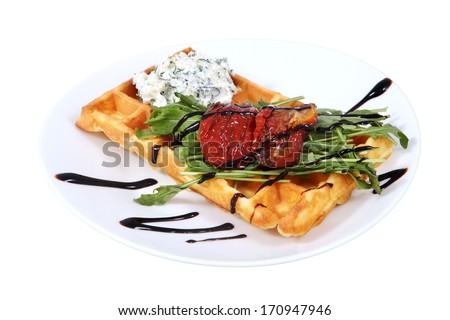 Belgian waffle with cream cheese and baked bell peppers, lies on a plate, isolated image on white background.