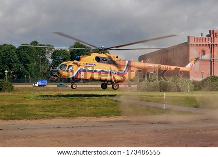 RUSSIA, ST PETERSBURG - JULY 19, 2007: Helicopter orange, Russian-made Mi-8, makes a landing on the grass lawn, near the Peter and Paul Fortress.