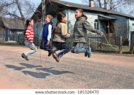 Tver, Russia - May 2, 2006: Russian, rural junior schoolchildren during recess, jumping rope, on the road near the school