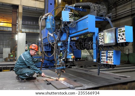 St. Petersburg, Russia - October 10, 2014: Industrial processing metal, automated submerged arc welding process. Work controls the setting for butt welding of steel sheets, metal working machine.