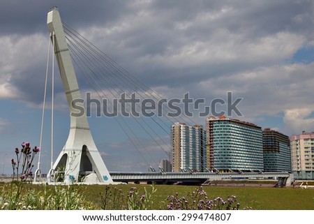 St. Petersburg, Russia - July 9, 2015: Single-span cable-stayed bridge with one pylon, Suspension bridge with a heating mains, guyed crossing, across the river in a residential area.