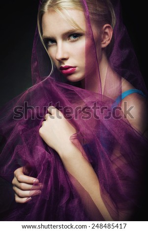 Portrait of a beautiful blond young woman with purple shawl In purple
