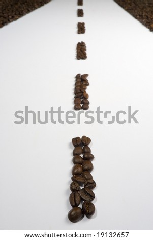 Lines of espresso coffee beans arranged to make a highway stretching into the distance