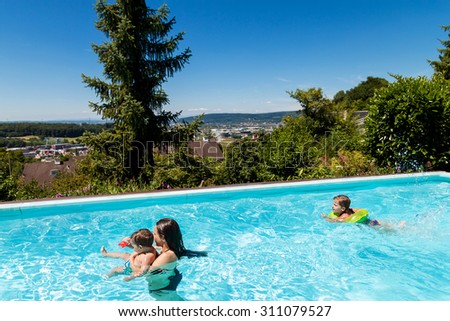 children swimming in the swimming pool in the garden