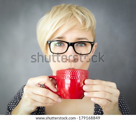portrait of young attractive woman drinking from red mug