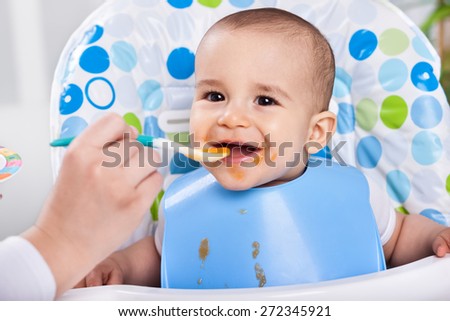 Smiling  messy baby likes to eat