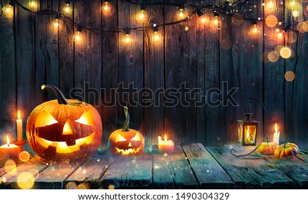 Halloween - Jack O' Lanterns - Candles And String Lights On Wooden Table 
