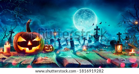 Jack O’ Lantern On Table In Spooky Graveyard At Night - Halloween With Full Moon - Contain 3d Illustration
