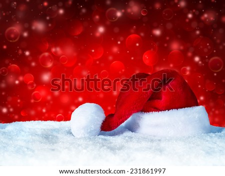Santa Claus hat with snow and red snowfall background