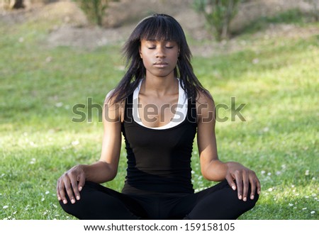 Young black girl doing yoga in the park