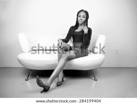 Beautiful fashion model on a white couch in black and white