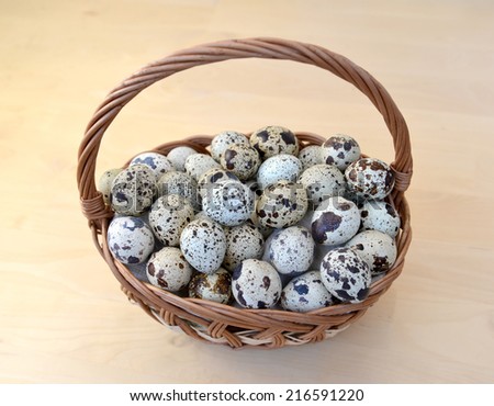 Quail eggs in a wattled basket on a light background, the top view