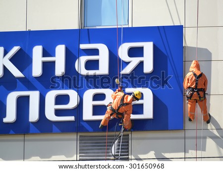 KALININGRAD, RUSSIA - APRIL 09, 2015: Industrial climbers wash a building facade by means of a sink of a high pressure