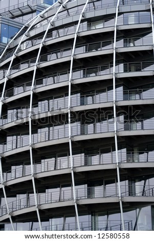 side of rounded steel office building with balconies