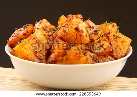 Fried potatoes with herbs and spices from Asian cuisine,.Shallow depth of field photograph.