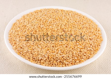 Toor dal, famous Indian legume also called yellow Pigeon peas in white plate..Selective focus.