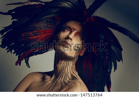 Fashion studio shot of beautiful woman with feathers. Air brush make-up.