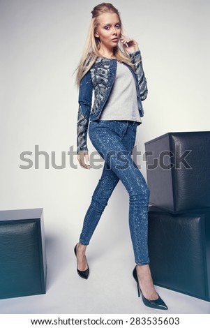 Beautiful young woman in denim clothes in studio interior