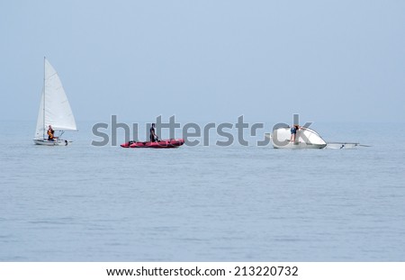 Saint Joseph Michigan, Circa June, 2014.  an instructor watches kids on a capsized boat, as they learn about water safetly at the  St Joseph Junior foundation sailing camp