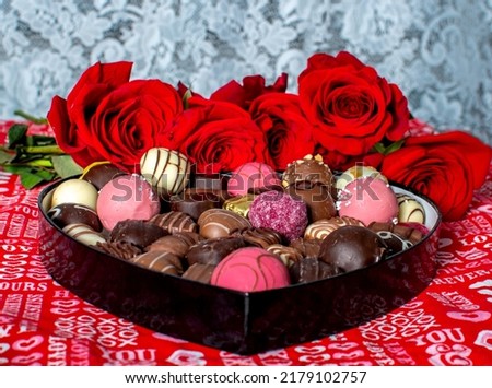 Heart shaped box of decedent chocolates and red roses against a lace background, the scene is set for romance Imagine de stoc © 