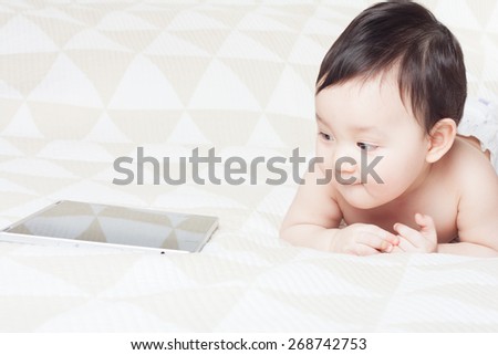 baby enthusiastically plays with the tablet PC