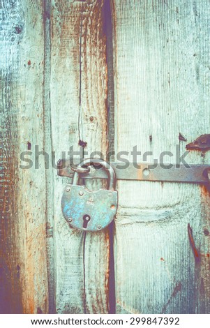 Old lock on the door. lock on the door of an old farmhouse . true village style . close-up. focus on lock. retro style toned photo