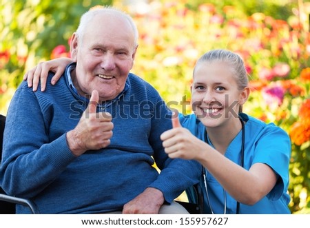 Young happy doctor showing thumbs up with his elderly patient.
