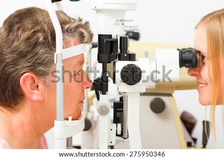 Young doctor and middle-aged patient during sight examination.