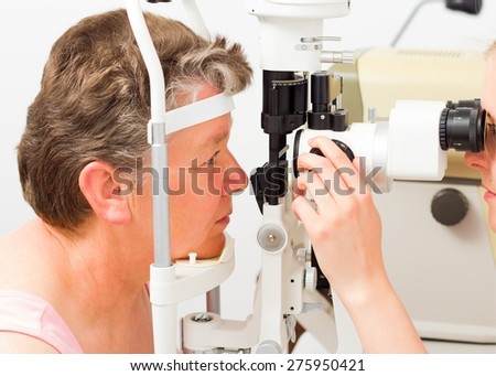 Kind middle-aged lady at the ophthalmology on a routine exam.