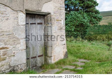 Old wooden door into ruined cottage