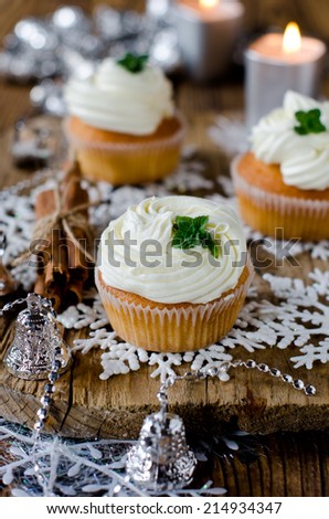 Christmas cupcakes with cream on a table decorated with Christmas decorations