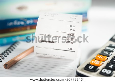 Grocery shopping list on notebook with calculator and pencil - money account management concept