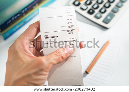Grocery shopping list in hand with calculator - money account management concept