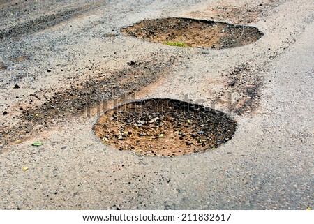Pothole in pavement signifying failing infrastructure