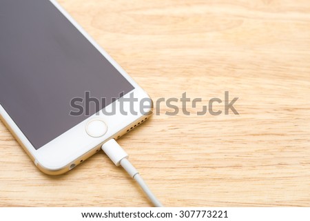 Smartphone charging with power bank on wood board