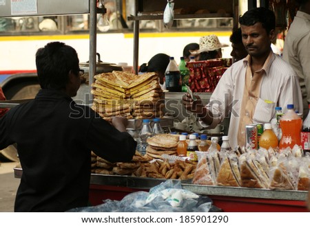 HYDERABAD,AP,INDIA- FEBRUARY 27: Vendor sell bakery food in a crowded road on February 27,2014 in Hyderabad,Ap,India. Popular street food is available in all places in india.