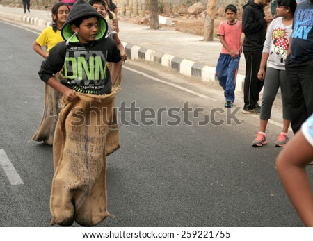 HYDERABAD,INDIA-FEBRUARY 28:People play sack race on the road during Happy roads program (vehicular traffic stopped) on February 28,2015 in Hyderabad,India.