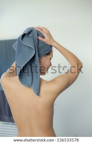 woman dries her hair with towel on her head
