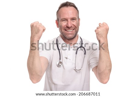 Enthusiastic unshaven middle-aged doctor punching the air with his fist celebrating a successful treatment or prognosis with a look of jubilation and glee, isolated on white