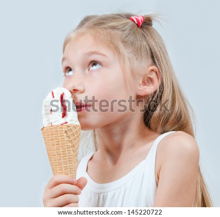 Delicious Ice Cream Cone. Little girl eating ice cream in studio isolated
