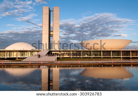 BRASILIA, BRAZIL - June 3, 2015: Brazilian National Congress reflected on water by sunset. The building was designed by Oscar Niemeyer in the modern Brazilian style.