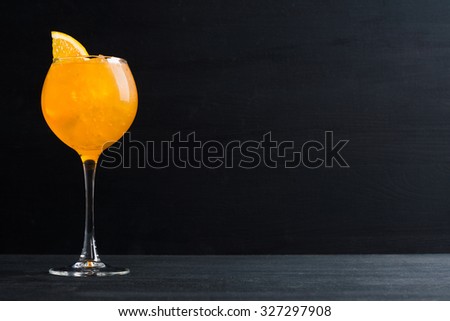 Orange cocktail with ice and oranges on the wooden background